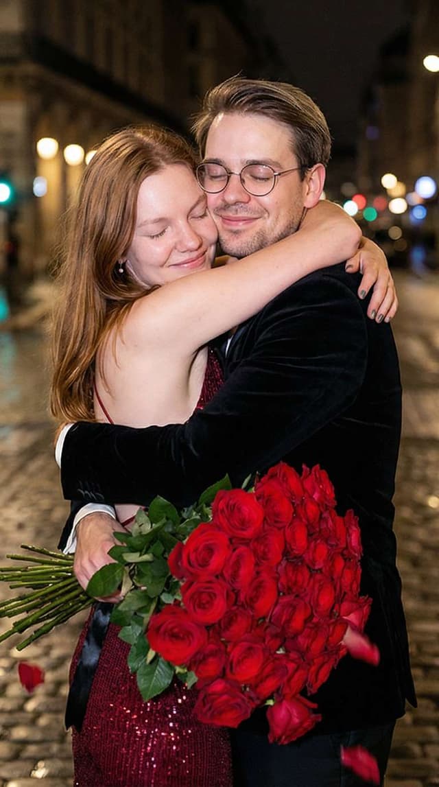 midnight in paris: couple with huge rose bouquet at night